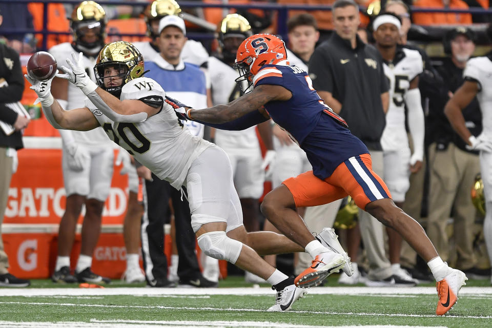 Wake Forest tight end Cameron Hite, left, catches a pass while defended by Syracuse defensive back Isaiah Johnson during the first half of an NCAA college football game in Syracuse, N.Y., Saturday, Nov. 25, 2023. (AP Photo/Adrian Kraus)