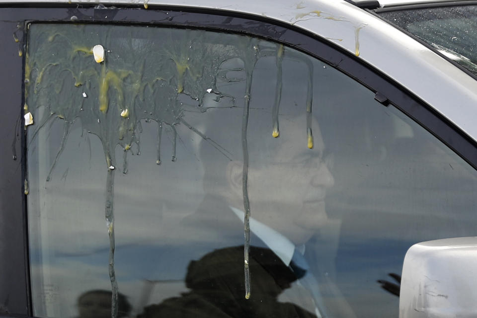 A lawmaker Michel Moussa sit on his car hit by eggs by the anti-government protesters trying to block a parliament session vote of confidence for the new government, in downtown Beirut, Lebanon, Tuesday, Feb. 11, 2020. Clashes broke out Tuesday between Lebanese protesters and security forces near the parliament building in central Beirut, where the new Cabinet is scheduled to submit its policy statement ahead of a vote of confidence. (AP Photo/Hussein Malla)