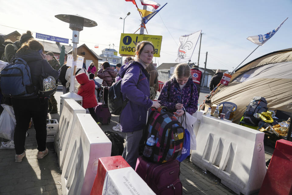 Refugees wait for a transport after fleeing the war from neighbouring Ukraine at the border crossing in Medyka, southeastern Poland, on Sunday, March 27, 2022. More than 3.7 million people have fled the war so far, Europe’s largest exodus since World War II. (AP Photo/Sergei Grits)