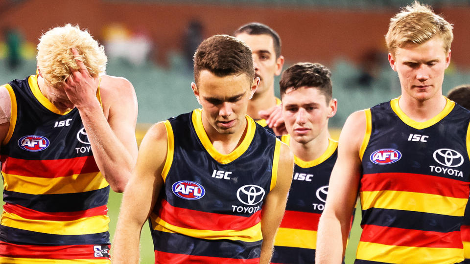 Adelaide Crows players players are pictured leaving the field with heads down after their recent loss to Melbourne.