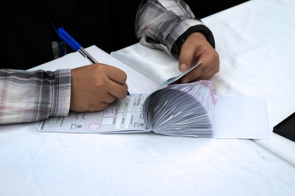 A staff member of a polling station prepares ballot papers during the Iranian presidential election in a polling station at the shrine of Saint Saleh in northern Tehran, Iran, Friday, June 28, 2024. Iranians were voting Friday in a snap election to replace the late President Ebrahim Raisi, killed in a helicopter crash last month, as public apathy has become pervasive in the Islamic Republic after years of economic woes, mass protests and tensions in the Middle East. (AP Photo/Vahid Salemi)