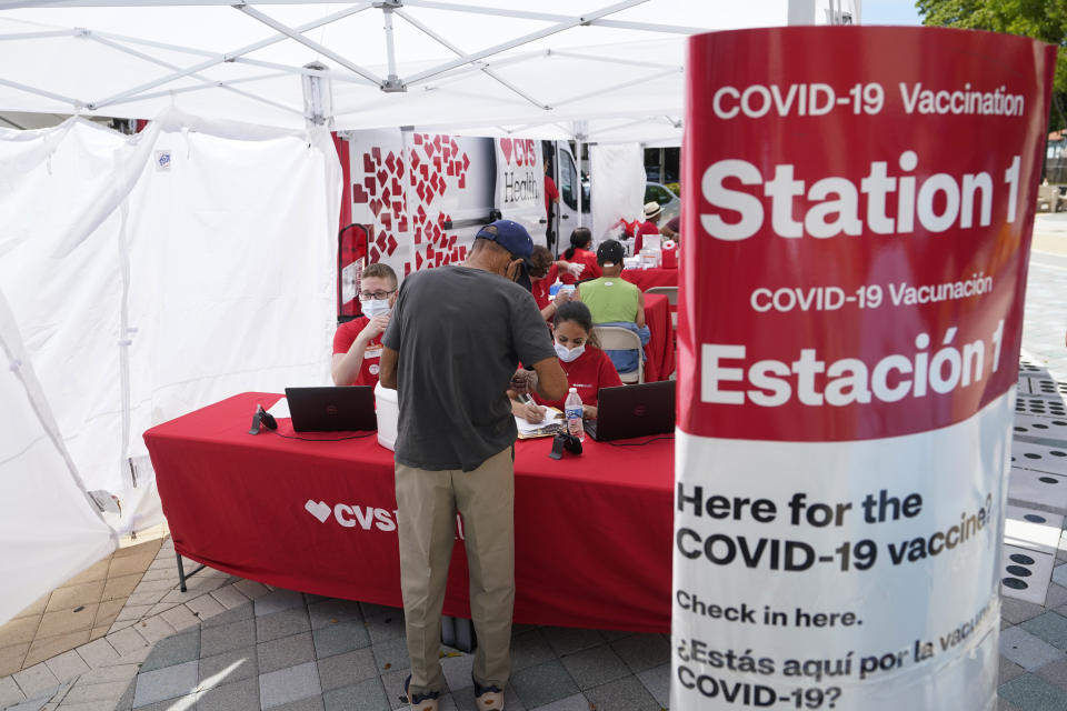 A man checks in to receive a vaccine at a pop-up vaccination site next to Maximo Gomez Park, also known as Domino Park, Monday, May 3, 2021, in the Little Havana neighborhood of Miami. (AP Photo/Wilfredo Lee)