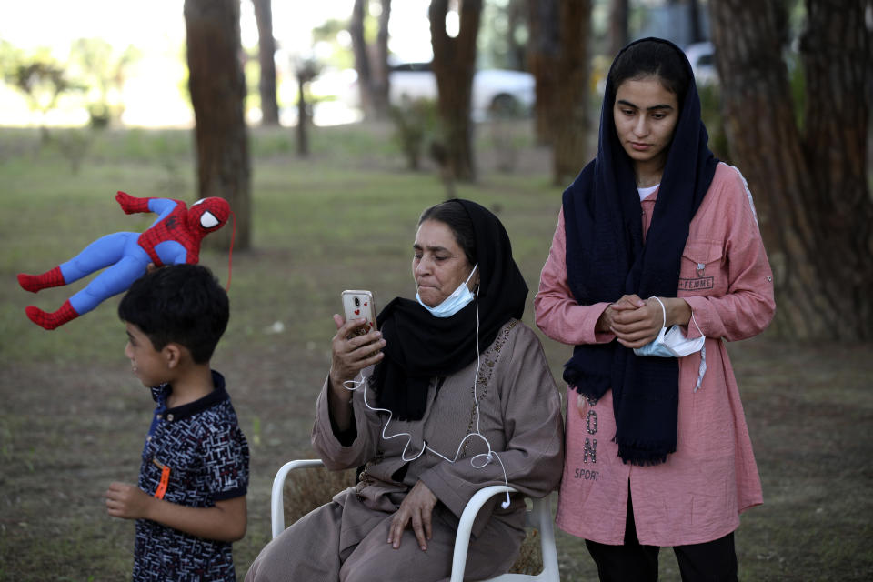 An Afghan woman speaks on her cellphone at a resort in Golem, some 45 kilometres (30 miles) west of Tirana, Albania, Friday, Aug. 27, 2021. Albania on Friday housed its first group of Afghan evacuees who made it out of their country despite days of chaos near the Kabul airport, including an attack claimed by the Islamic State group. (AP Photo/Franc Zhurda)