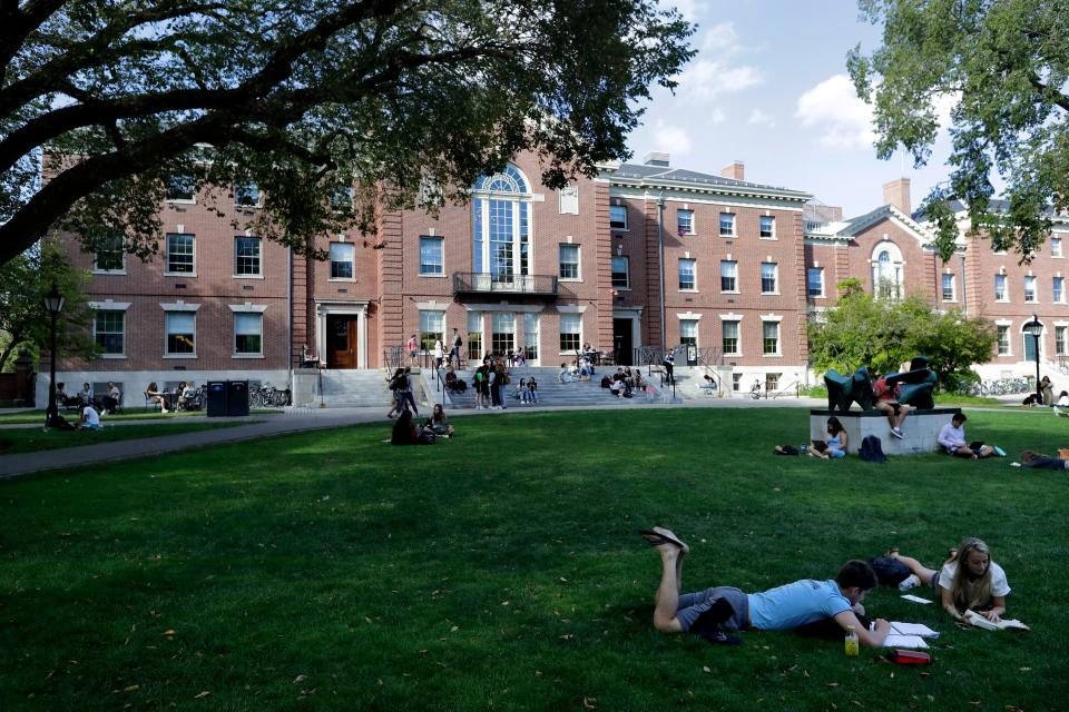 People rest on grass while reading at Brown University in Providence, R.I., in September 2019.