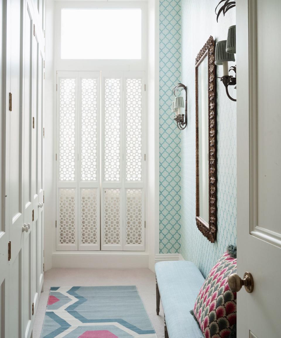 Blue wallpaper and bench, white cupboards