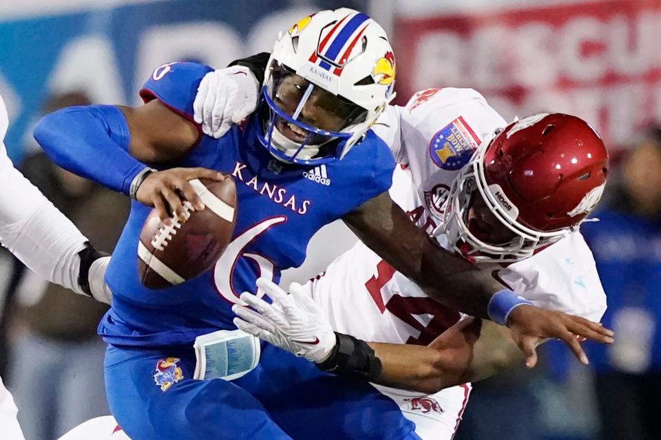 Arkansas defensive lineman Jordan Domineck (14) pressures Kansas quarterback Jalon Daniels (6) during the first half of the Liberty Bowl NCAA college football game Wednesday, Dec. 28, 2022, in Memphis, Tenn. (AP Photo/Rogelio V. Solis)