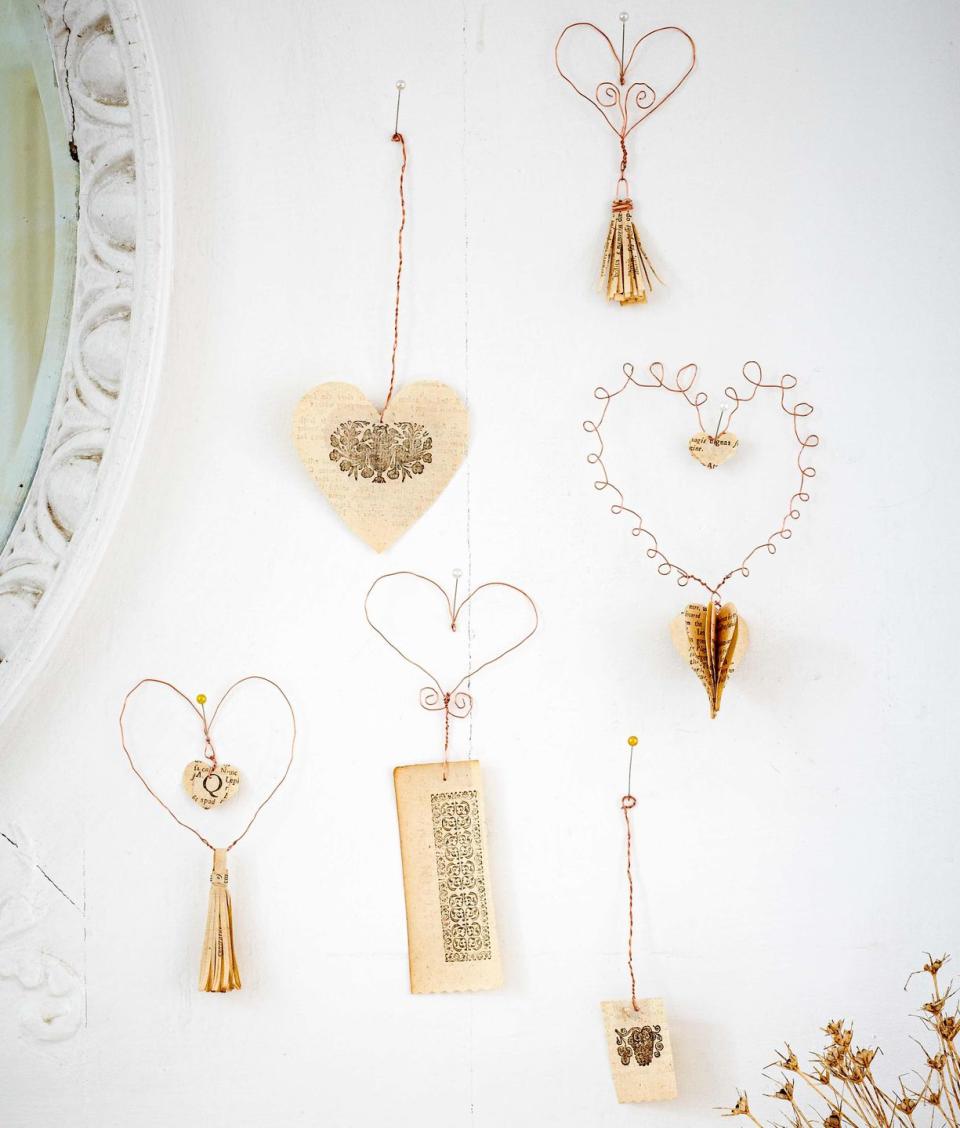 wire and paper hearts hanging on a white wall