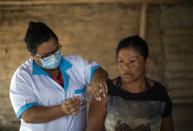 A healthcare worker injects a Guarani woman with a dose of China's Sinovac COVID-19 vaccine at the Mata Verde Bonita village in Marica, Rio de Janeiro state, Brazil, Thursday, Feb. 25, 2021, as part of a mass immunization program aimed at inoculating all of Rio’s 16 million residents by the end of the year. (AP Photo/Bruna Prado)