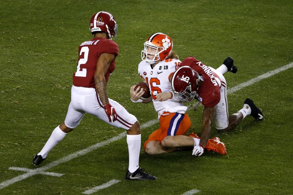 Clemson's Trevor Lawrence tries to slide before getting hit by Alabama defenders last January.