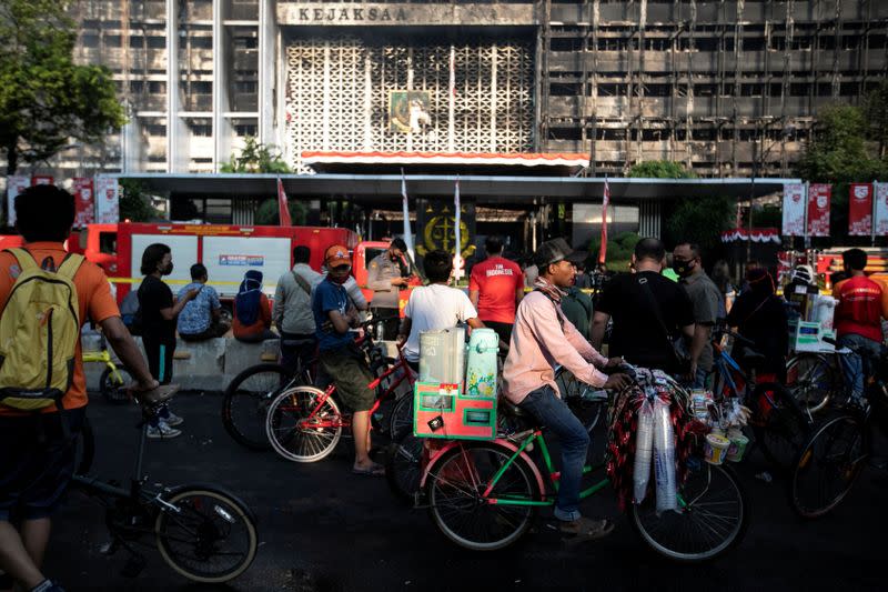 People gather to watch outside following fire at the Attorney General's office in Jakarta