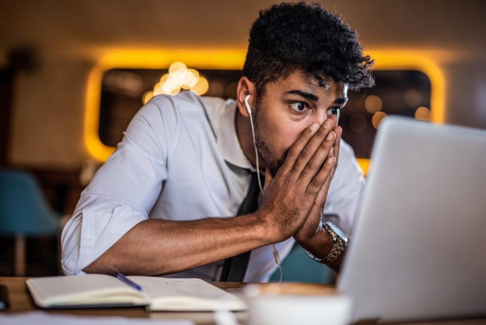 An investor looking at his computer with a surprised expression.