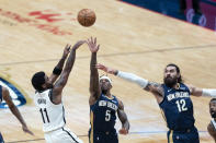 Brooklyn Nets guard Kyrie Irving (11) shoots against New Orleans Pelicans guard Eric Bledsoe (5) and center Steven Adams (12) in the first half of an NBA basketball game in New Orleans, Tuesday, April 20, 2021. (AP Photo/Gerald Herbert)