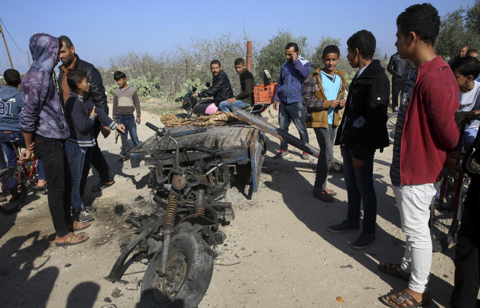 FILE - In this Monday, Nov. 12, 2018 file photo, Palestinians inspect a vehicle that was destroyed in an Israeli raid that killed seven Hamas Palestinian militants, including a local Hamas commander, late Sunday, east of Khan Younis, southern Gaza Strip. An Israeli army officer was also killed in the incurison into Gaza. The fighting came just days after Israel and Hamas reached indirect deals, backed by Qatar and Egypt, to allow cash and fuel into Gaza. A month after a heavy round of Israel-Hamas fighting, the undercover Israeli operation that sparked the battle remains clouded in mystery(AP Photo/Adel Hana, File)