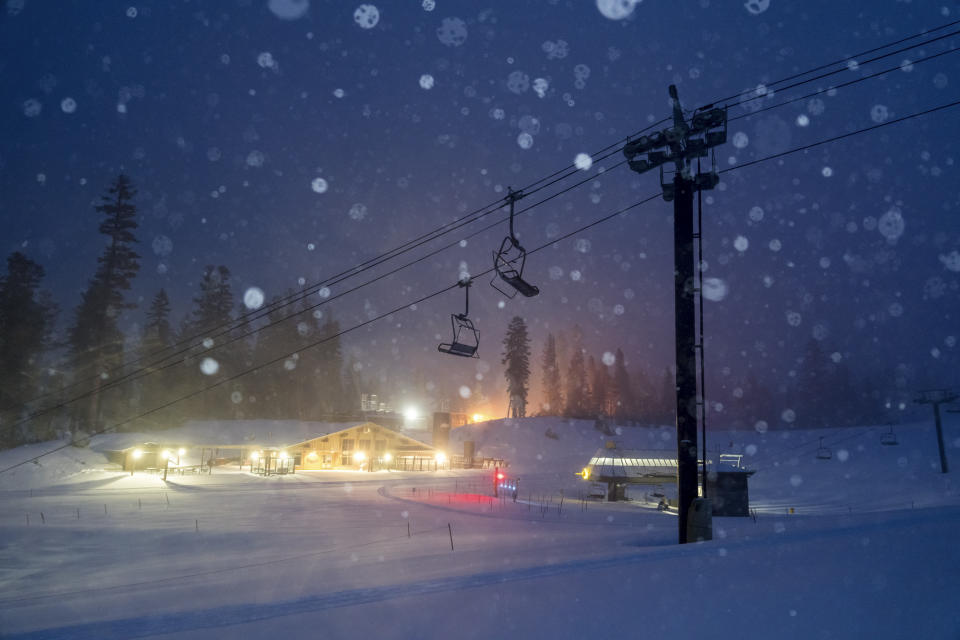 In this photo provided by the Mammoth Mountain Ski Area, snow falls around a lodge and lifts in Mammoth Lakes, Calif., Monday, Jan. 22, 2024. (Christian Pondella/Mammoth Mountain Ski Area via AP)