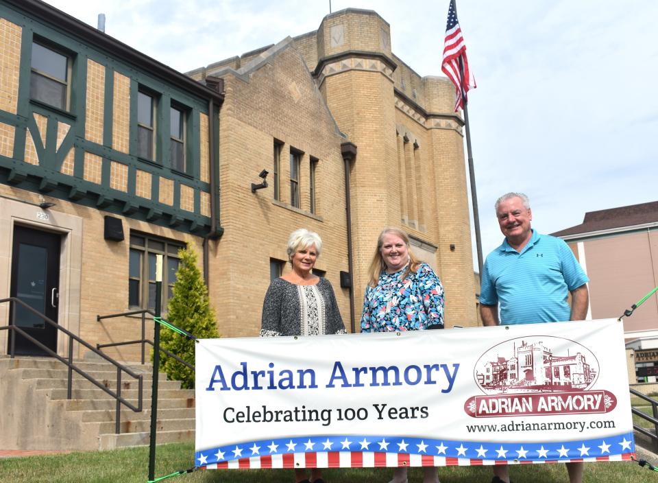 The Adrian Armory Events Center is turning 100 this year, and to celebrate, an open house is planned for Friday, July 5 from 5:00 to 8:00 p.m. at the Armory location, located near downtown Adrian at 230 W. Maumee St. Pictured are Mary Murray, Sheila Blair and Mark Murray, left to right, in front of the Armory and next to a promotional banner for the Armory's 100th anniversary.