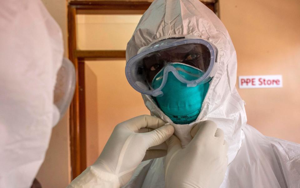 A Ugandan doctor puts on PPE at the Entebbe Ebola treatment centre, near Kampala - ISAAC KASAMANI/EPA-EFE/Shutterstock 