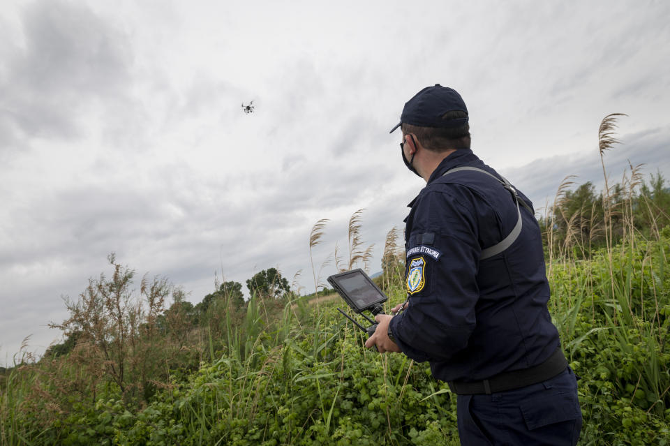 Police drone operator Thanassis Kyriakidis pilots a drone during a patrol at Evros river, near the village of Feres, at the Greek -Turkish border, Greece, Friday, May 21, 2021. An automated hi-tech surveillance network being built on the Greek-Turkish border aiming at detecting migrants early and deterring them from crossing, with river and land patrols using searchlights and long-range acoustic devices. (AP Photo/Giannis Papanikos)