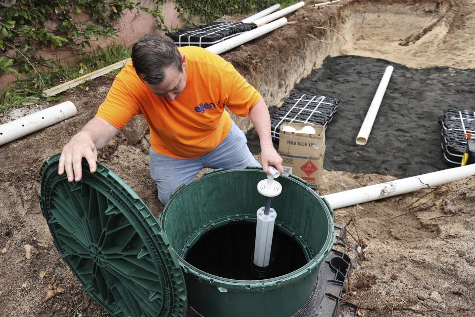 Jim King, CEO of Eljen Corporation, examines a septic tank installed to replace a cesspool in Waialua, Hawaii on Thursday, May 11, 2023. Hawaii has 83,000 of cesspools, more than any other U.S. state, and many of them are close to the shoreline. (AP Photo/Marco Garcia)