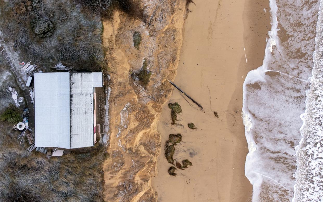 A Hemsby home at risk of collapse as high tides cut into sandy cliffs - Joe Giddens/PA Wire