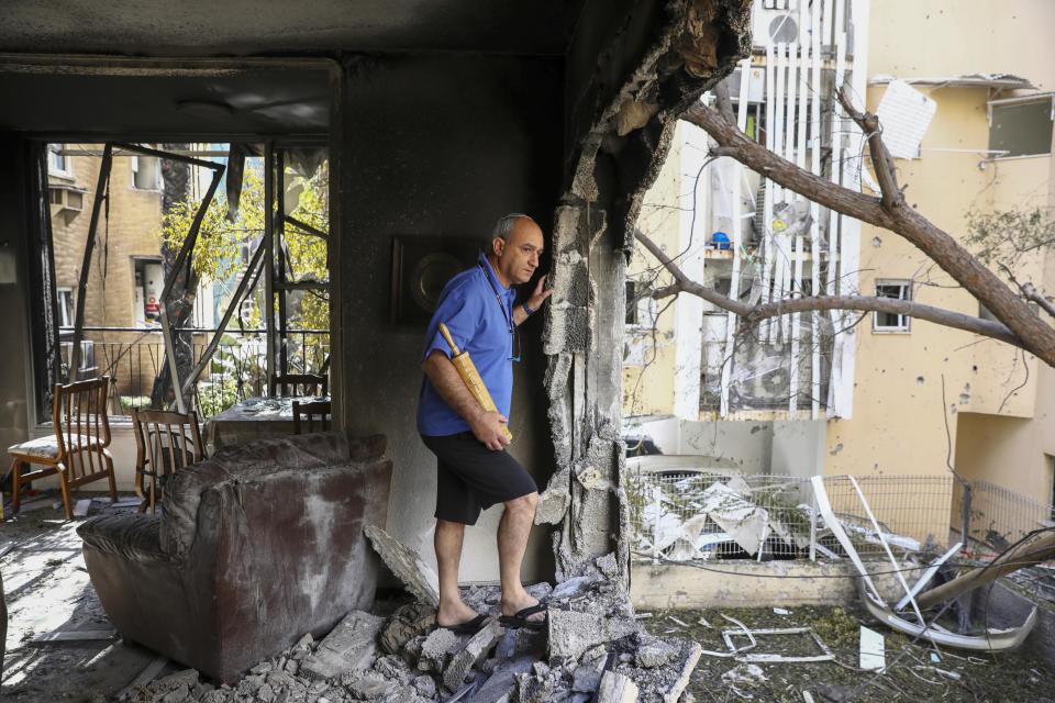 Image: A member of Sror family inspect the rocket damage to their apartment in Petah Tikva, Israel, on Thursday. (Oded Balilty / AP)