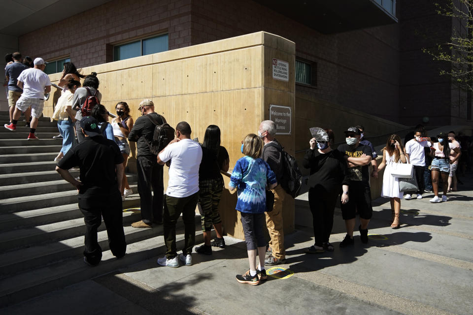 People wait in line for marriage licenses at the Marriage License Bureau, Friday, April 2, 2021, in Las Vegas. The bureau was seeing busier than normal traffic ahead of 4/3/21, a popular day to get married in Las Vegas. (AP Photo/John Locher)