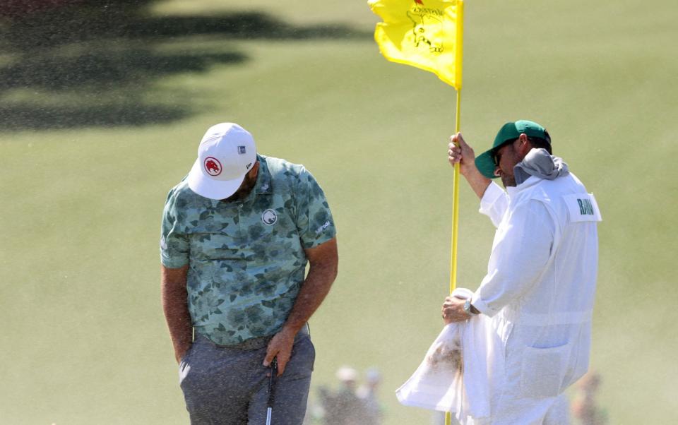 Spain's Jon Rahm reacts as sand from the bunker is blown by the wind on the 9th hole