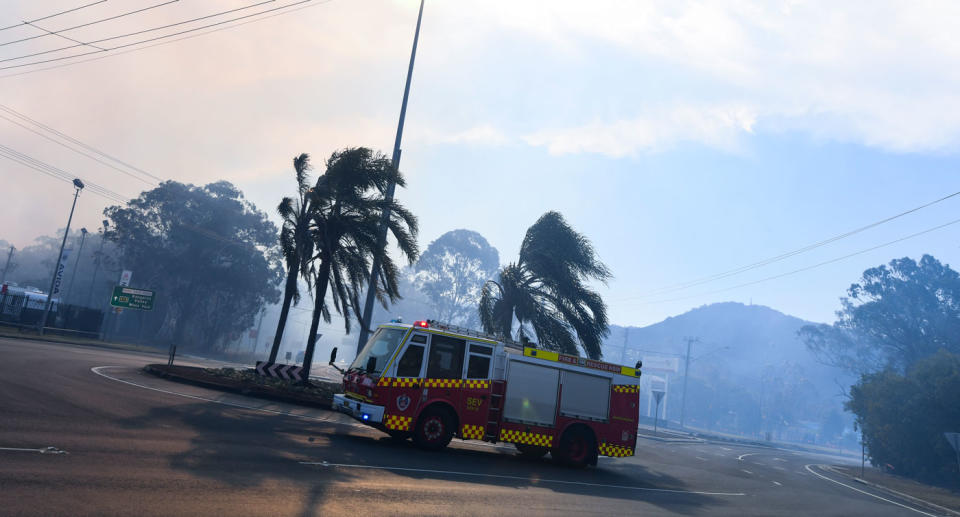 NSW fire fighters work on containing an out of control bushfire in Bomaderry near Nowra on the state’s south coast. Source: AAP