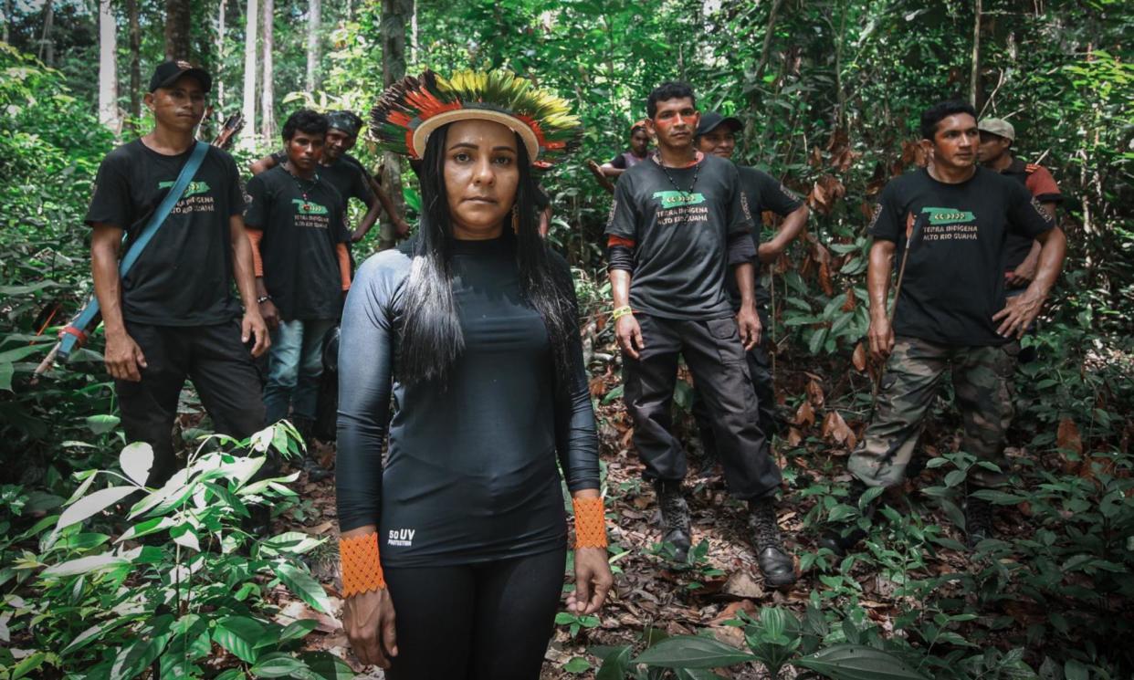 <span>Puyr Tembé in her <em>cocar</em> headdress with her team of forest guardians. ‘We protect 80% of the remaining biodiversity on the planet,’ she says of her fellow Indigenous people. ‘At least 600 of us land defenders have been murdered since 2014.’</span><span>Photograph: Fernanda Luna/We Are Guardians</span>