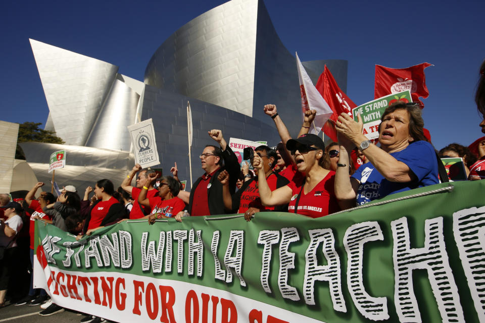 FILE - In this Dec. 15, 2018, file photo, United Teachers Los Angeles leaders are joined by thousands of teachers as they march past the Walt Disney Concert Hall downtown Los Angeles. The union representing striking teachers in Los Angeles says the strike will continue into its sixth school day on Tuesday, Jan. 22, 2019, regardless of the outcome of negotiations Monday. (AP Photo/Damian Dovarganes, File)