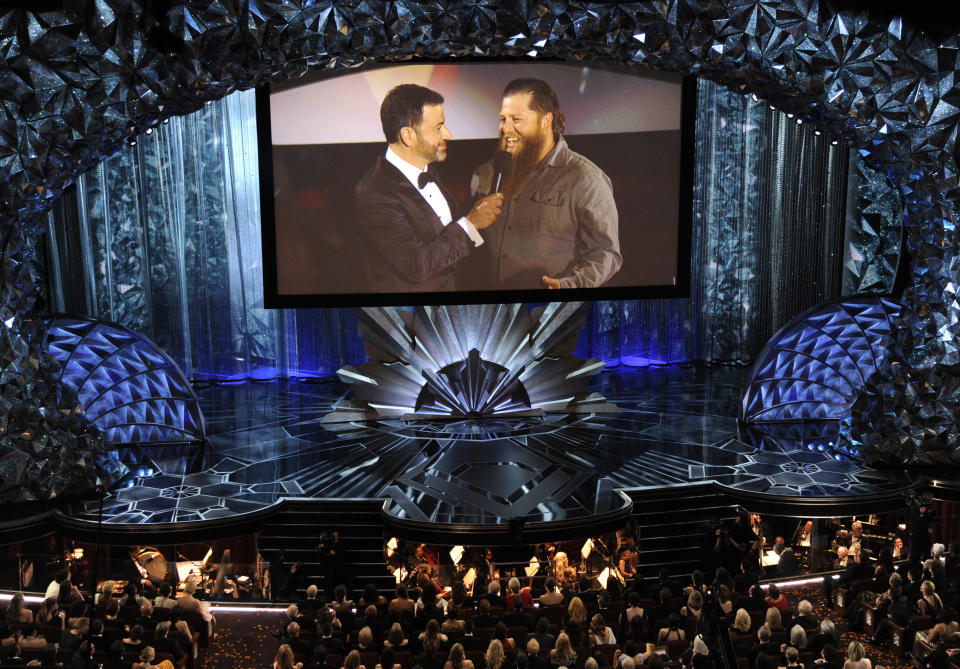 Host Jimmy Kimmel, left, speaks with a member of the movie theater audience