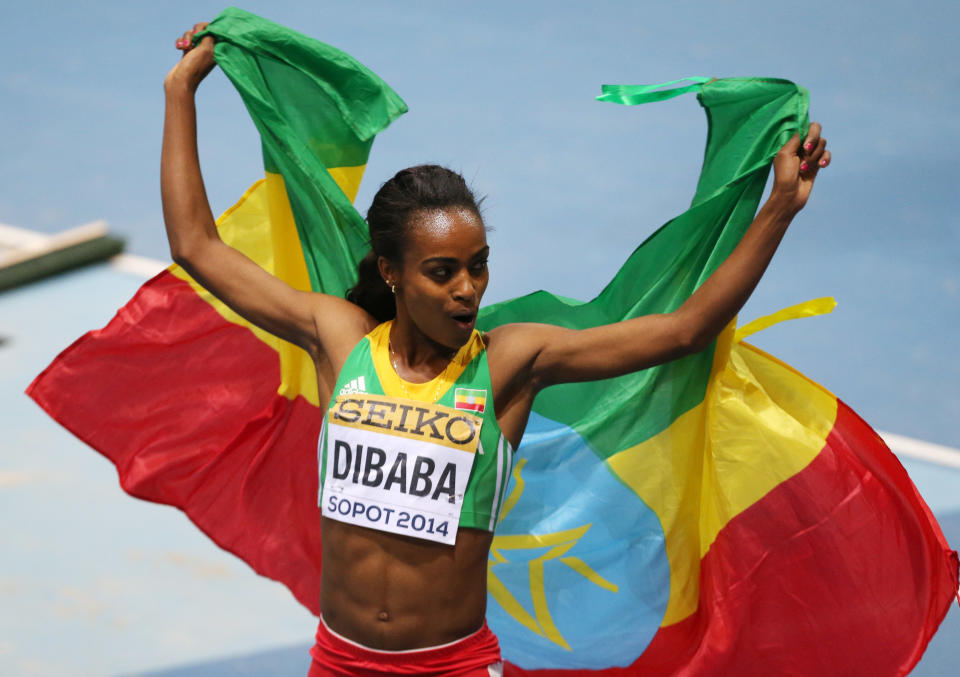 Ethiopia's Genzebe Dibaba carries the national flag after winning the women's 3000m final during the Athletics World Indoor Championships in Sopot, Poland, Sunday, March 9, 2014. (AP Photo/Petr David Josek)