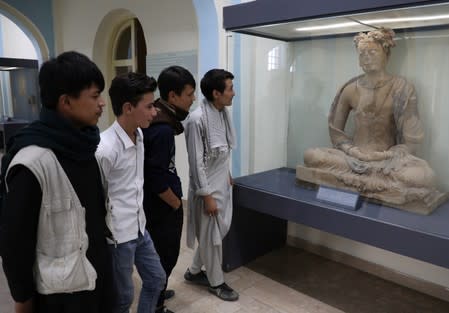 Afghan youth look at a statue that is displayed at the National Museum in Kabul, Afghanistan