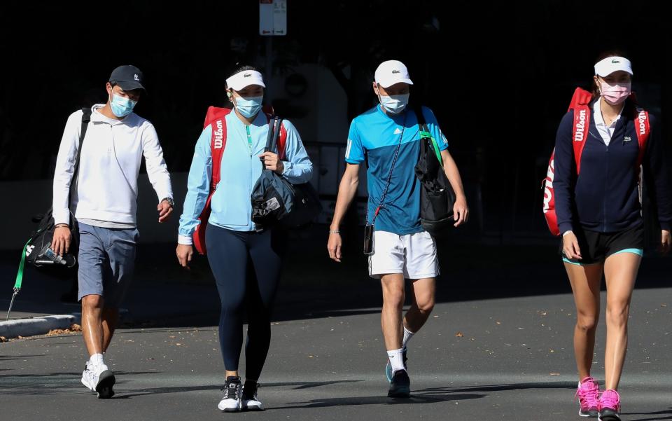 A group of tennis players and trainers are seen walking to practice at training courts on the opposite side of the hotel in Melbourne - Getty