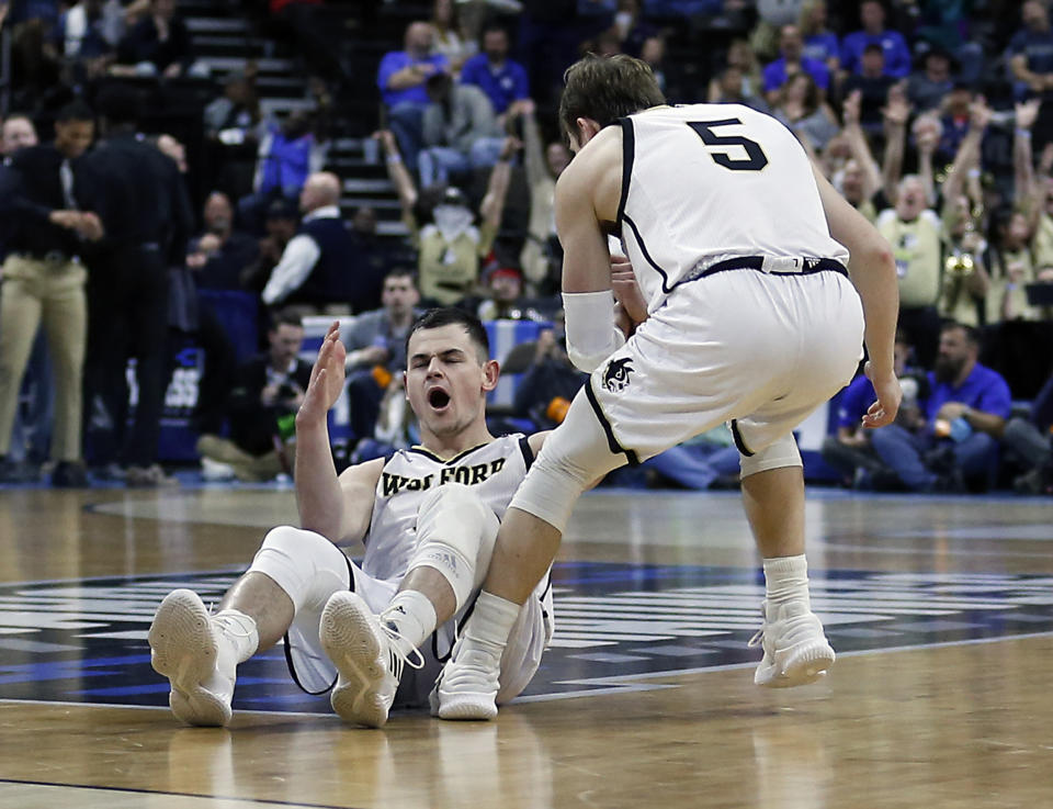 Wofford's Fletcher Magee, left, reacts after drawing a foul on a 3-point shot as Storm Murphy (5) helps him up during the first half against Seton Hall in a first-round game in the NCAA men’s college basketball tournament in Jacksonville, Fla., Thursday, March 21, 2019. (AP Photo/Stephen B. Morton)