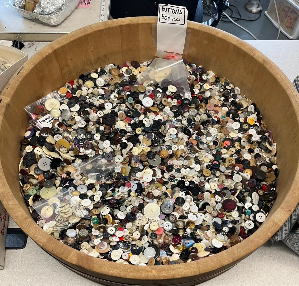 A traditional Japanese cypress-wood mixing bowl for making vinegared rice, repurposed to hold buttons.