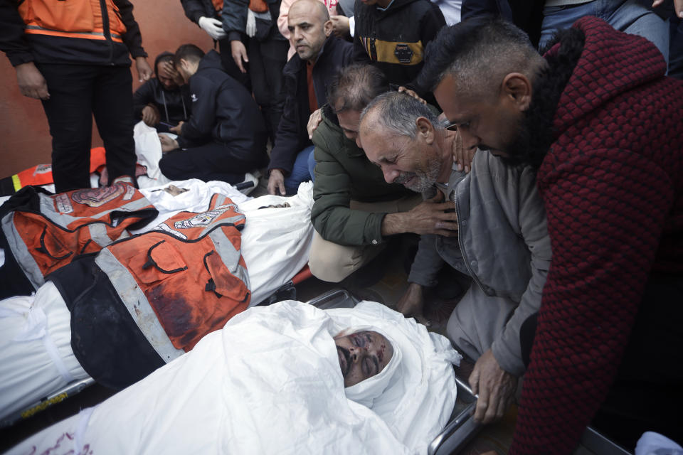 Palestinians mourn over the bodies of Al Jazeera cameraman, Samer Abu Daqqa, and three civil defence officers who were killed in Israeli airstrikes, during their funerals in the town of Khan Younis, southern Gaza Strip. Saturday, Dec. 16, 2023. (AP Photo/Mohammed Dahman)