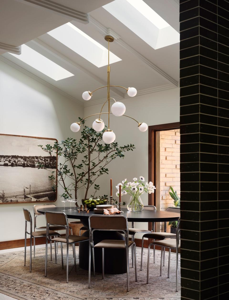 A dining room with large skylights and a massive chandelier.