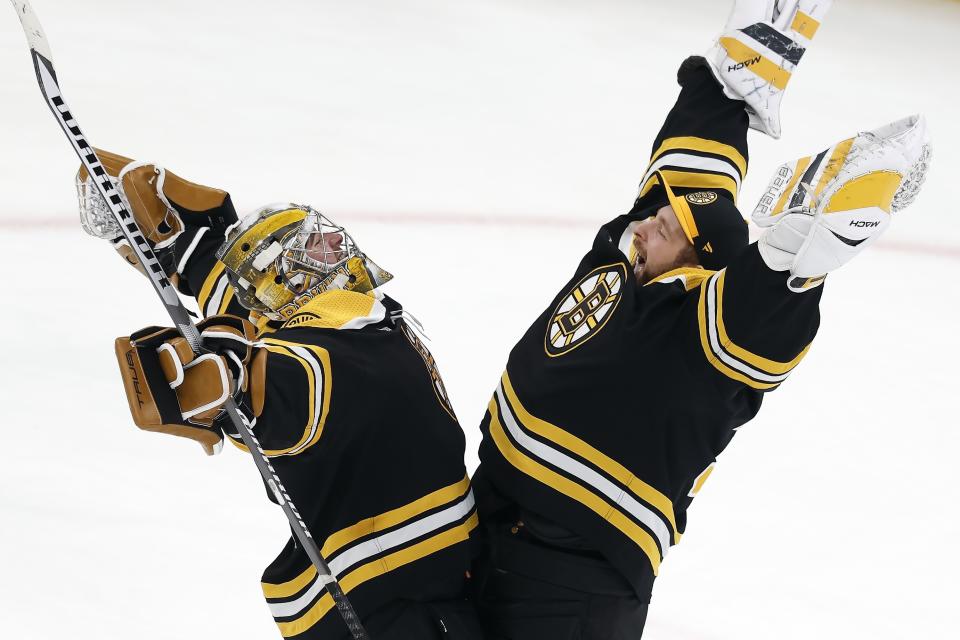 Boston Bruins' Jeremy Swayman, left, celebrates with Linus Ullmark after defeating the Columbus Blue Jackets in an NHL hockey game, Saturday, Dec. 17, 2022, in Boston. (AP Photo/Michael Dwyer)