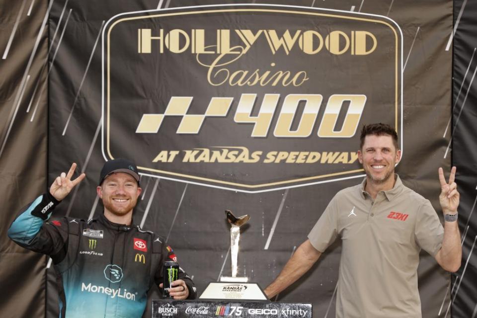 KANSAS CITY, KANSAS - SEPTEMBER 10: Tyler Reddick MoneyLion Toyota, driver of the #45 23XI Racing, (L) and 23XI Racing co-owner, Denny Hamlin pose for photos in victory lane after winning the NASCAR Cup Series Hollywood Casino 400 at Kansas Speedway on September 10, 2023 in Kansas City, Kansas. (Photo by Sean Gardner/Getty Images)