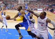 Golden State Warriors forward Andre Iguodala, left, puts up a shot as Los Angeles Clippers center DeAndre Jordan, center, and forward Glen Davis defend during the first half in Game 1 of an opening-round NBA basketball playoff series, Saturday, April 19, 2014, in Los Angeles. (AP Photo/Mark J. Terrill)