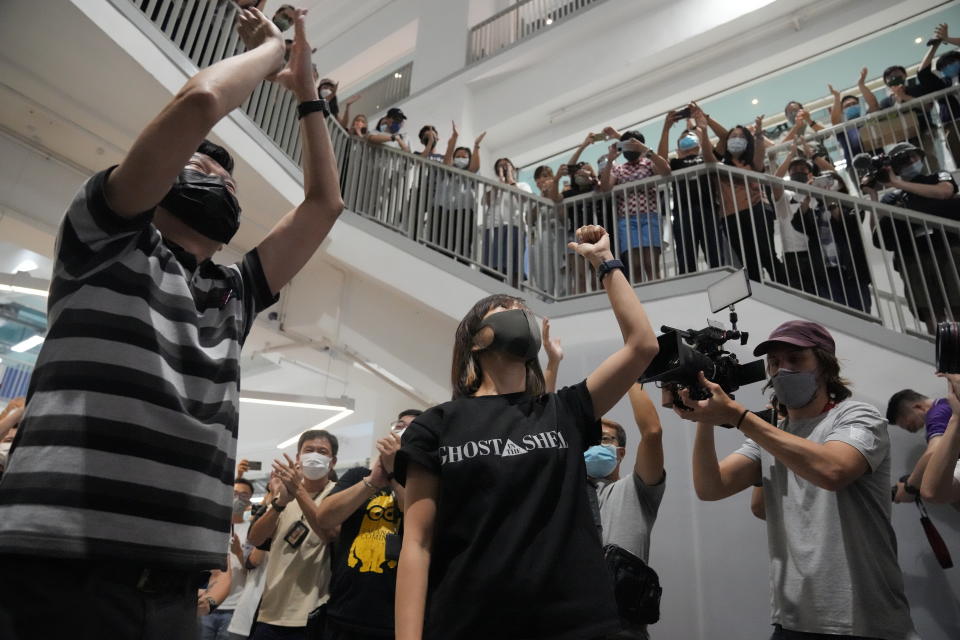 Chan Pui-man, right, associate publisher of Apple Daily and Lam Man-chung, Executive Editor-in-Chief of Apple Daily gesture at the headquarters in Hong Kong, Wednesday, June 23, 2021. Hong Kong's pro-democracy Apple Daily newspaper will stop publishing Thursday, following last week's arrest of five editors and executives and the freezing of $2.3 million in assets under the city's one-year-old national security law. (AP Photo/Kin Cheung)