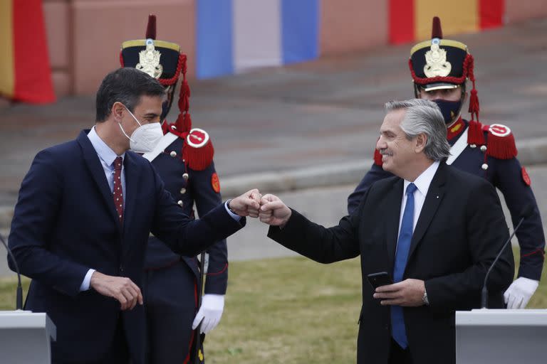 El primer ministro de España, Pedro Sánchez, a la izquierda, golpea con el puño al presidente de Argentina, Alberto Fernández, en medio de la pandemia de COVID-19, al final de su conferencia de prensa durante la visita de un día de Sánchez a Buenos Aires, Argentina, el miércoles 9 de junio de 2021. (AP Foto/Natacha Pisarenko)