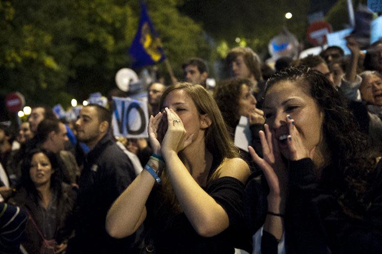 Protestors gather and shout near Parliament demonstrating against austerity measures announced by the Spanish government in Madrid, Spain, Saturday, Sept. 29, 2012. Tens of thousands of Spaniards and Portuguese rallied in the streets to protest enduring deep economic pain from austerity cuts. In Madrid, demonstrators approached parliament for the third time this week to vent their anger against tax hikes, government spending cuts and the highest unemployment rate among the 17 nations that use the euro. (AP Photo/Daniel Ochoa De Olza)