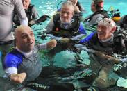 French Philippe Croizon (L), 44, celebrates on January 10, 2013with a group of 15 Belgian divers after becoming the first quadruple amputee to dive at a depth of 33 meters in the deepest swiming pool in the world in Brussels. He used flippers attached to prosthetic limbs to dive to the bottom of the pool to set a new world record for an amputee. Croizon had all four limbs amputated in 1994 after being struck by an electric shock of more than 20,000 volts as he tried to remove a TV antenna from a roof. He has swum across the English Channel and all five intercontinental channels. AFP PHOTO GEORGES GOBETGEORGES GOBET/AFP/Getty Images