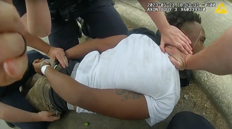 A screenshot from bodycam footage of Asheville Police Department officers arresting Devon Whitmire.