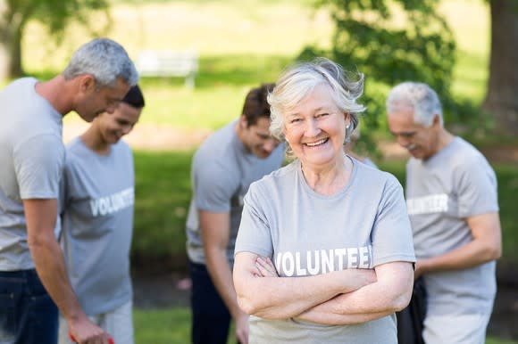 Older woman with "volunteer" on her shirt smiles at the camera.