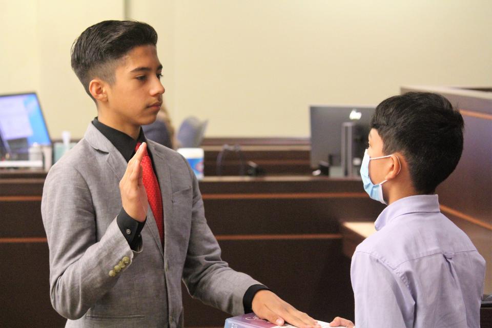 A witness is sworn in during a Corpus Christi Catholic School student mock trial Friday, May 13, in Grand Haven.