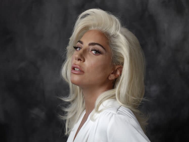 A woman with blond hair tilts her head back as she looks off to her side