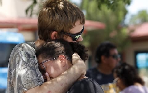  Kendall Long (L) comforts Kianna Long (R) who was in the freezer section of a Walmart during a shooting incident, in El Paso - Credit: Rex