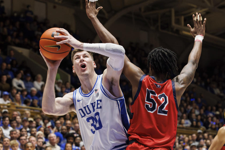 FILE - Duke's Kyle Filipowski (30) is defended by Southern Indiana's Kiyron Powell (52) during the second half of an NCAA college basketball game in Durham, N.C., Friday, Nov. 24, 2023. Filipowski is a member of the AP All-ACC team in voting released Tuesday, March 12, 2024.(AP Photo/Ben McKeown, File)